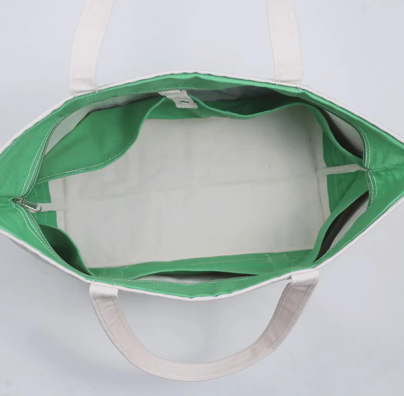 a green and white tote bag sitting on top of a white table